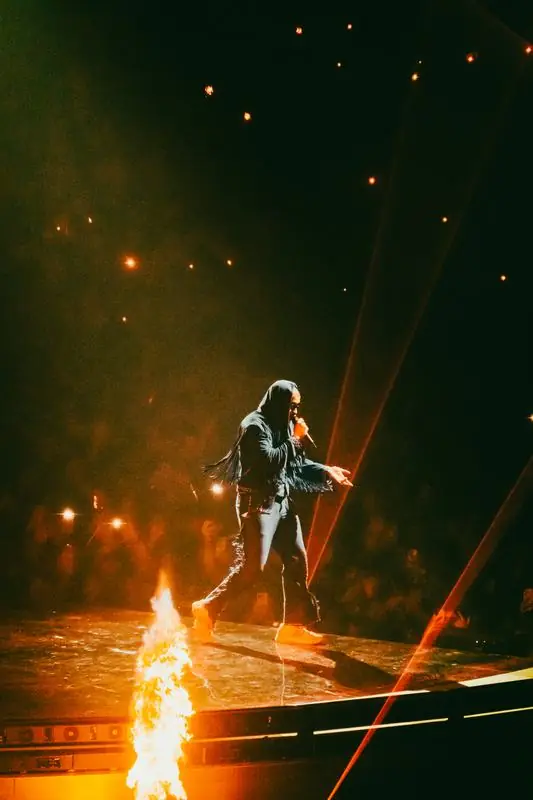 Performer in a fringed jacket surrounded by flames