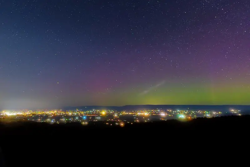 Northern lights over city lights