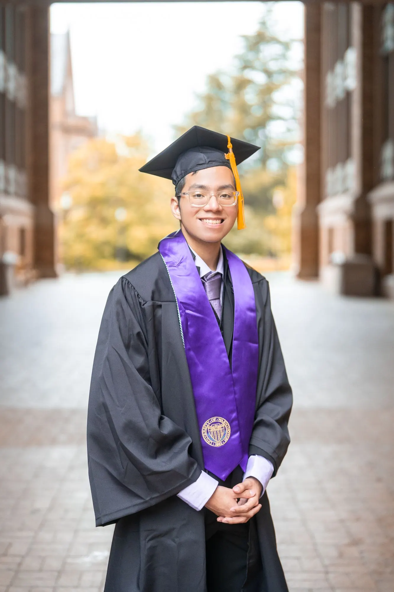 Graduate in cap and gown with a purple stole