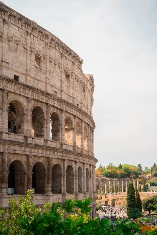 The Colosseum in Rome with greenery and tourists