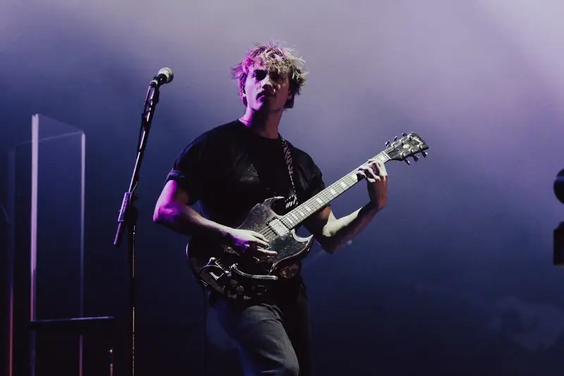 Guitarist under purple and blue lights