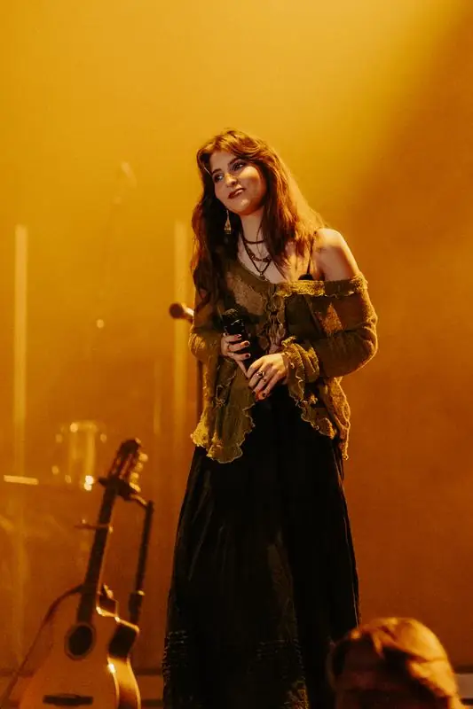 Singer in a torn brown sweater