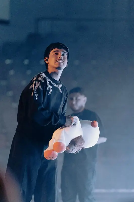 Singer holding a plush dog