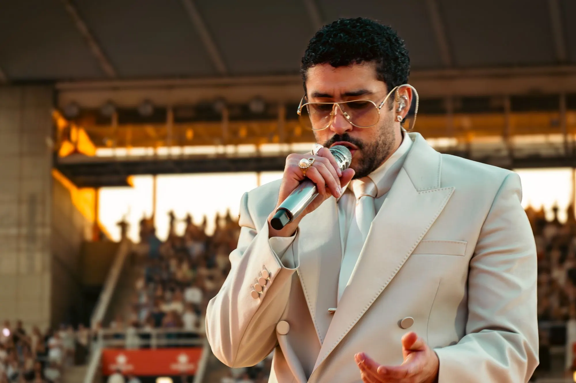 Bad Bunny in a tan suit singing in Barcelona